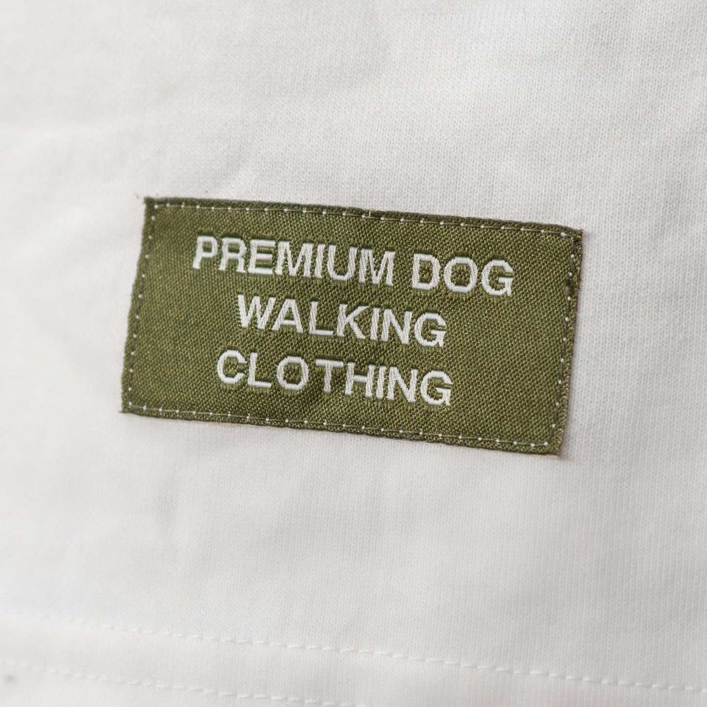 White t shirt with a green label on a gray background