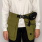 Person wearing a white sweatshirt with 'MALIKO DOGS' text, green tactical vest, and black waist bag on a plain background.
