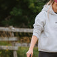 Person training a dog outdoors with trees in the background